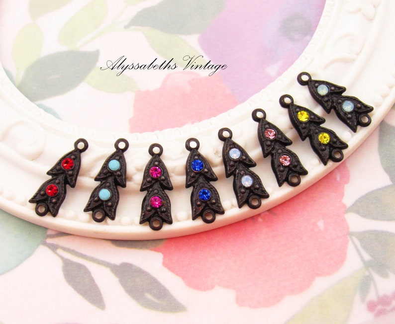 Puede incluir: Surtido de ocho abalorios de metal de tono bronce antiguo con forma de l&aacute;grima. Cada abalorio presenta tres piedras de cristal de diferentes colores, incluyendo rojo, azul, turquesa, rosa, amarillo y transparente.