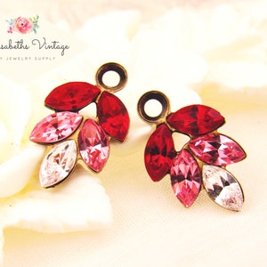 May include: A pair of vintage-style earrings featuring a cluster of marquise-cut crystals in shades of red, pink, and clear white. The crystals are set in a gold-toned metal base. The earrings are from Alyssabeths Vintage Etsy Jewelry Supply.