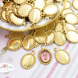 May include: A collection of gold oval-shaped metal charms with a beaded border. Each charm has two jump rings for attaching to jewelry or other crafts.