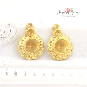 May include: Two gold-toned metal earring charms with a round, slightly domed center and a decorative border of small beads. The charms have a loop at the top for attaching to earrings.