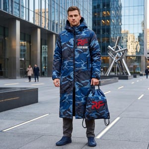 May include: A long, hooded blue camouflage coat with a front zipper, featuring a red RF logo and the text YOUR NAME on the chest. The coat is paired with a matching blue camouflage drawstring backpack that also displays a red RF logo on the front.