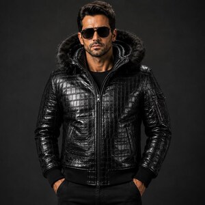 Könnte beinhalten: Eine schwarze Jacke mit texturiertem Krokodilleder-Muster, ausgestattet mit einer Kapuze mit dunklem Kunstfellbesatz, einem Frontreißverschluss sowie schwarzen Rippbündchen an den Ärmeln und am Saum, getragen über einem schlichten schwarzen Shirt.