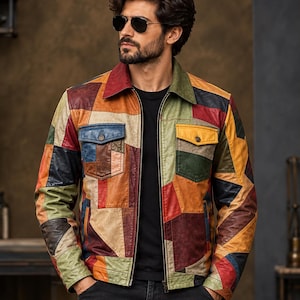 Può includere: Una giacca in pelle patchwork multicolore con colletto a punta, chiusura frontale con zip e due tasche sul petto con patta abbottonata. La giacca è realizzata con vari pannelli geometrici in pelle nelle tonalità rosso, giallo, blu, verde e marrone.