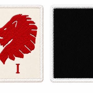 May include: Two rectangular embroidered patches with white stitched borders. The left patch features a red lion head silhouette and the red Roman numeral I on a cream background. The right patch is solid black with a white stitched border.