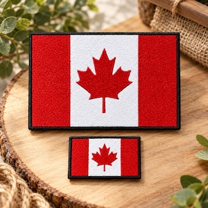 May include: Two rectangular embroidered patches featuring the Canadian flag design. Each patch displays a central red maple leaf on a white vertical stripe, flanked by two solid red vertical stripes, all enclosed by a black stitched border.