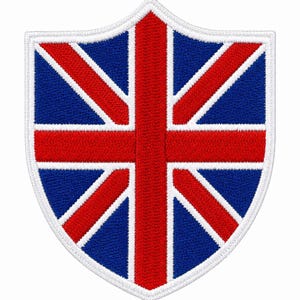 May include: A shield-shaped embroidered patch featuring the Union Jack flag design. The patch displays a central red cross and diagonal red stripes outlined in white, set against a deep blue background, all bordered by a thick white stitched edge.