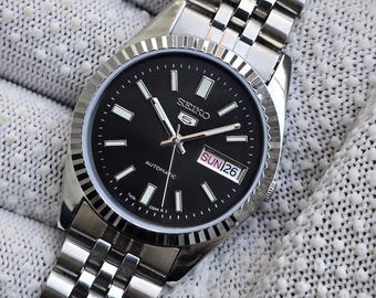 Vintage, gerenoveerde Seiko 5 Automatic herenhorloge van staal met dag- en datumweergave en 17 jewels, Japans model.