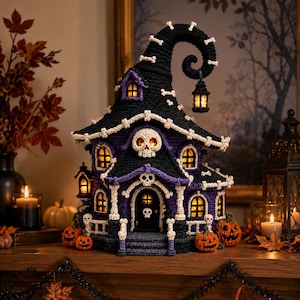 May include: A crocheted haunted house decoration in black and purple yarn, featuring a tall curved roof, multiple illuminated windows, and white skull accents. The structure is adorned with small crocheted pumpkins at the base and a hanging lantern.