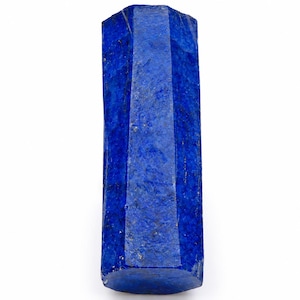 Op de afbeelding: Een hoge, cilindervormige lapis lazuli kristal met een diepe, verzadigde koningsblauwe kleur. Het oppervlak van de steen heeft een getextureerde, natuurlijke afwerking met subtiele variaties in tint en kleine, verspreide gouden pyrietspikkels.