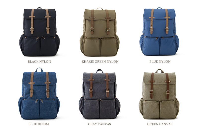 May include: Six different backpacks in various colors and materials. The backpacks are all the same style, with two large pockets on the front and a flap with two buckles. The colors are black nylon, khaki green nylon, blue nylon, blue denim, gray canvas, and green canvas.