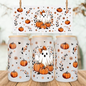 May include: Three frosted glass tumblers with bamboo lids and clear straws, featuring a repeating pattern of orange pumpkins, black leafy vines, small orange flowers, and a central white ghost wearing an orange bow surrounded by pumpkins.