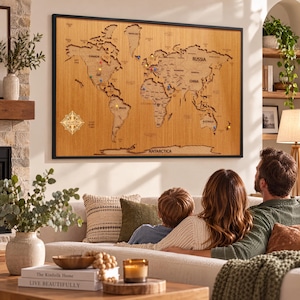 Pode incluir: Um grande mapa-múndi de madeira retangular para parede com moldura preta. O mapa apresenta continentes cortados a laser com nomes de países e fronteiras, acentuado por percevejos coloridos e um design de rosa dos ventos.