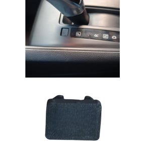 May include: A black rectangular plastic shift lock release cover with a textured surface, shown alongside a car center console gear shifter assembly featuring a silver handle and a black panel with P, R, N, and D gear position indicators.
