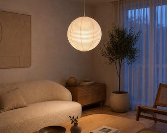 May include: A spherical paper pendant light fixture with a ribbed texture, suspended from the ceiling by a thin cord. The lamp emits a soft, warm glow, illuminating the surrounding space with a diffused light that highlights its round shape.