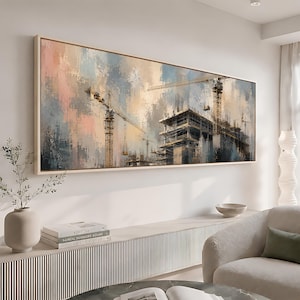 May include: A large rectangular wall art piece featuring an impressionistic painting of a construction site. The scene depicts a multi-story building frame under construction with tall yellow cranes against a soft, blended sky of pink, blue, and grey.