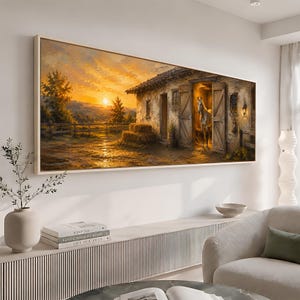 Puede incluir: Un cuadro panorámico que muestra un granero de piedra rústico al atardecer. Un caballo blanco se encuentra en la puerta abierta. La escena incluye luz dorada, colinas, una valla de madera y pacas de heno, enmarcado en un borde de madera clara.