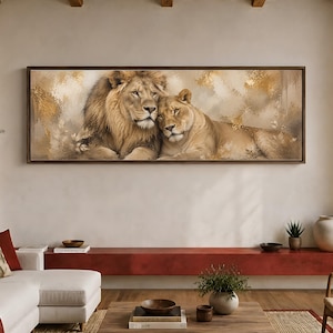 May include: A panoramic rectangular wall art piece featuring a male lion with a full mane and a lioness resting together. The artwork displays a soft, textured background in shades of cream, beige, and metallic gold, framed in a dark brown wood.