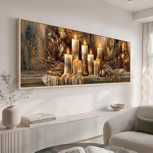 Puede incluir: Un cuadro rectangular que presenta una composición horizontal de varias velas de pilar encendidas de diferentes alturas. La escena incluye follaje seco de color marrón dorado, superficies texturizadas y detalles de tela suave en tonos cálidos.