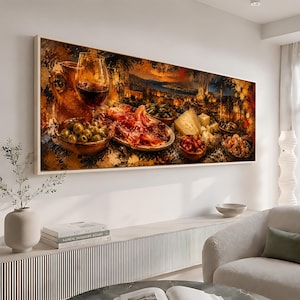 May include: A rectangular wall art print featuring a warm-toned, painterly scene of a Mediterranean feast. The composition includes a glass of red wine, a ceramic pitcher, bowls of green olives, cured meat, and various cheeses against a sunset city.