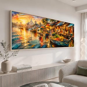 Può includere: Una stampa artistica da parete rettangolare con un dipinto impressionista di un vivace mercato galleggiante al tramonto. La scena raffigura barche in legno piene di prodotti colorati su un fiume, con la sagoma di un tempio e luce dorata.