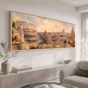 Puede incluir: Un lienzo panorámico de arte mural que presenta una pintura detallada del Coliseo romano y las ruinas antiguas circundantes bajo un cielo cálido de tonos dorados. La obra muestra estructuras arquitectónicas, columnas de piedra y follaje suave en tonos beige, oro y naranja apagado, enmarcada en un borde fino de madera clara.