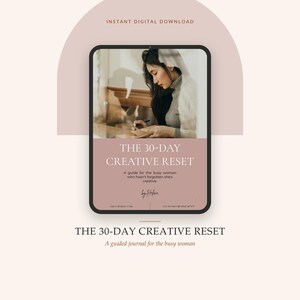 May include: A digital tablet displaying a cover for The 30-Day Creative Reset, a guide for the busy woman who hasn't forgotten she's creative, by Helene. The screen shows a person writing in a journal, with the title and subtitle in white text.