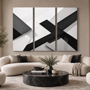 May include: A triptych wall art set featuring a geometric composition of bold black, white, and gray diagonal stripes and intersecting lines. The three rectangular panels create a cohesive abstract design with sharp angles and layered monochromatic shapes.