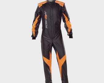 May include: A black racing suit with vibrant orange accents on the shoulders, sleeves, and legs. The garment features a high collar, long sleeves with black cuffs, and the text KS-ART printed vertically in white on the chest area.