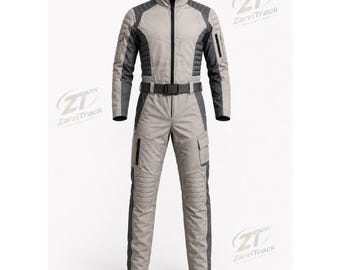 May include: A light grey and dark grey jumpsuit featuring a high collar, a full-length front zip, and a black waist belt. The garment includes quilted shoulder and knee panels, multiple utility pockets on the sleeves and legs, and the ZarriTrack logo.