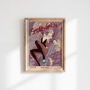 Op de afbeelding: Een ingelijste stripboekposter met Spider-Gwen in een wit, zwart en magentakleurig pak dat door een stad springt. De tekst luidt Spider-Gwen bovenaan en Gwen Stacy onderaan met een Marvel-logo. De lijst is gemaakt van licht, verweerd hout.