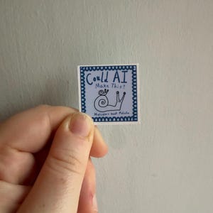 May include: A square sticker with a blue scalloped border on a white background. It features a hand-drawn snail illustration and the text "Could AI Make This?" at the top, with "Malcolm + Small Malcolm" written in smaller letters at the bottom.