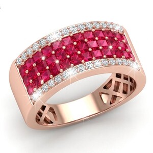May include: A rose gold ring featuring three rows of square-cut red rubies in the center, flanked by two rows of small round white diamonds on the edges. The band has a lattice-style cutout design on the sides and the Habib logo in the corner.