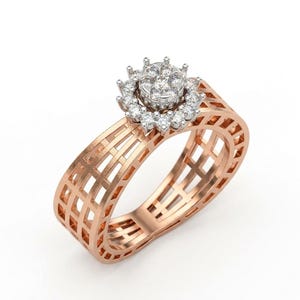 May include: A rose gold ring featuring a wide, open-work lattice band design. The top of the ring is adorned with a circular cluster of small, clear, round-cut stones set in white metal, creating a floral-like arrangement with a central stone.