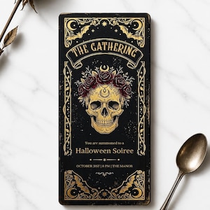 May include: A rectangular black invitation card featuring gold ornate borders, bats, and a central skull wearing a crown of dark red roses. The text reads: THE GATHERING, You are summoned to a Halloween Soiree, OCTOBER 31ST | 8 PM | THE MANOR.