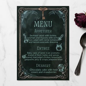 May include: A rectangular menu card with a dark green background and an ornate metallic frame featuring a bat-shaped key at the top. The text reads The MENU, APPETIZER, ENTREE, and DESSERT, listing various food items with small icon illustrations.
