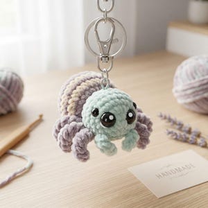 Söt plyschvirkad spindelnyckelring, handgjord plyschhoppande spindelväskeberlock, mjuk pastellfärgad amigurumi-djurklämma, estetisk ryggsäcksaccessoar