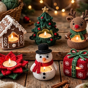 May include: A collection of six crocheted Christmas candle holders including a gingerbread house, a green tree, a brown reindeer, a red poinsettia, a white snowman with a black hat, and a red gift box with green ribbon, each holding a lit tea light.