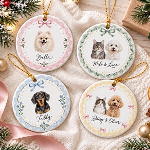 May include: Four round white ceramic ornaments with gold hanging strings. Each features a scalloped border in pink, green, blue, or yellow, decorated with bows and floral accents. The ornaments display pet portraits with names: Bella, Milo & Luna, Teddy, and Daisy & Oliver.