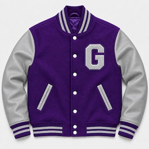 Puede incluir: Una chaqueta universitaria de color morado con mangas gris claro, que presenta un gran parche con la letra G en blanco en el pecho izquierdo. La chaqueta tiene cierre frontal con botones a presión, dos bolsillos laterales y ribetes a rayas.
