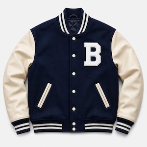 Pode incluir: Uma jaqueta varsity azul-marinho com mangas na cor creme, um grande emblema com a letra B branca no peito esquerdo, fecho frontal com botões de pressão e acabamento canelado listrado na gola, nos punhos e na bainha. Possui dois bolsos.