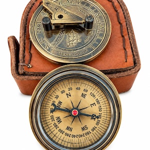 Puede incluir: Un reloj de sol de latón con números romanos, el año 1827 y el texto WEST LONDON, junto a una brújula magnética circular de latón con esfera dorada y marcas negras, todo ello sobre un estuche de cuero marrón.