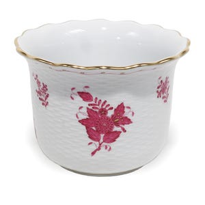 Pode incluir: Um vaso de porcelana branca com uma superfície texturizada de cestaria, decorado com motivos florais magenta pintados à mão. A borda larga e recortada tem um acabamento dourado fino e o interior é de porcelana branca lisa.