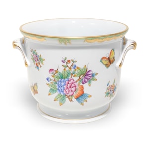 Pode incluir: Um vaso de porcelana branca com um bouquet floral central de flores rosas, azuis e laranjas, rodeado por borboletas coloridas e folhas verdes. O recipiente possui duas alças laterais e uma borda dourada no topo e na base.