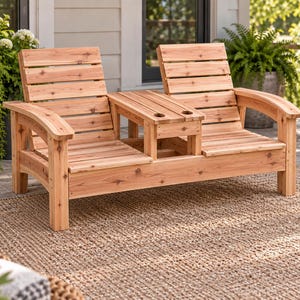 Può includere: Una panchina da esterno in legno marrone chiaro con due sedute a doghe e un tavolino centrale. La console include due portabicchieri circolari. La panchina presenta braccioli curvi e uno schienale a doghe, realizzata in legno naturale.