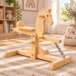 May include: A light-colored wooden rocking horse toy featuring a central support beam, a flat seat, and a metal spring mechanism attached to the base. The structure includes horizontal handlebars and a stylized horse head silhouette with a mane.