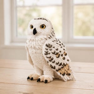 Peut inclure: Une figurine de harfang des neiges au crochet en fil blanc avec des motifs tachetés brun foncé et beige sur les ailes et la queue. Le hibou a un bec noir, de grands yeux jaunes avec des pupilles noires et des pattes beige clair avec des griffes noires.
