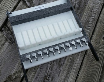 May include: A gray metal soap cutter with white plastic inserts and silver metal knobs. The cutter is labeled "BUDS WOODSHOP".