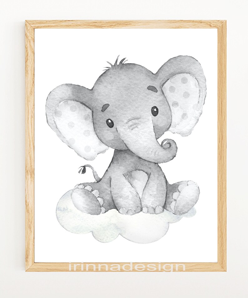 May include: A watercolor illustration of a gray elephant sitting on a cloud. The elephant has a spotted ear and a curled trunk. The illustration is framed in a light wood frame.