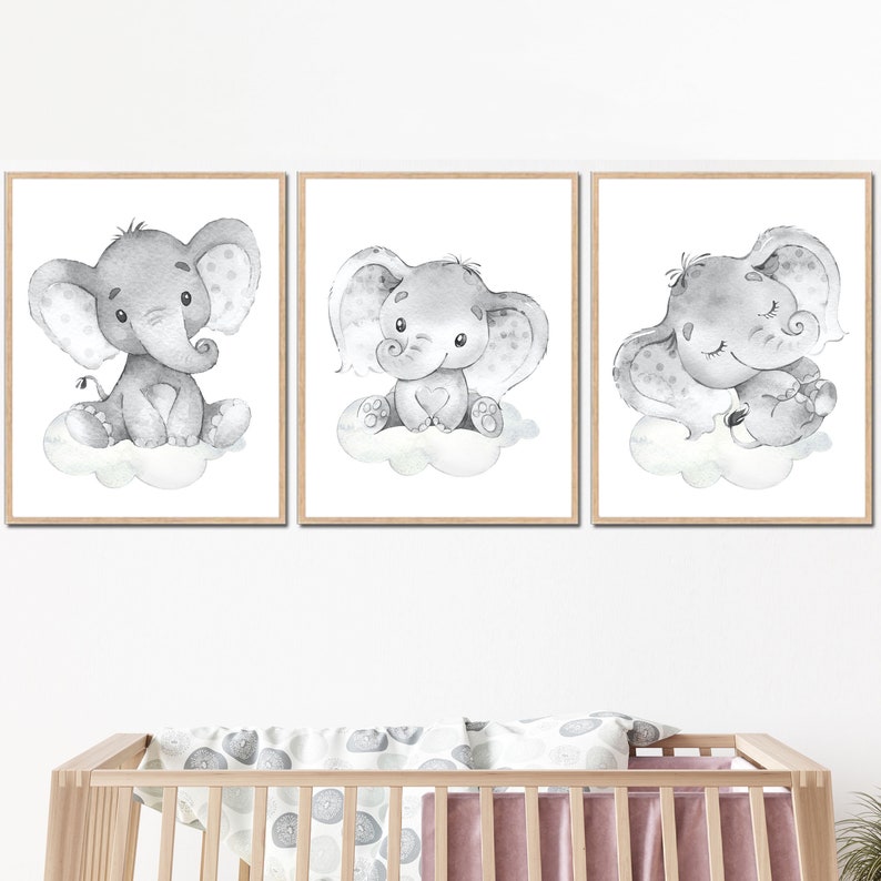 May include: Three watercolor illustrations of gray elephants on a white background. Each elephant is in a different pose, one sitting, one standing, and one sleeping. The illustrations are framed in a simple wooden frame.