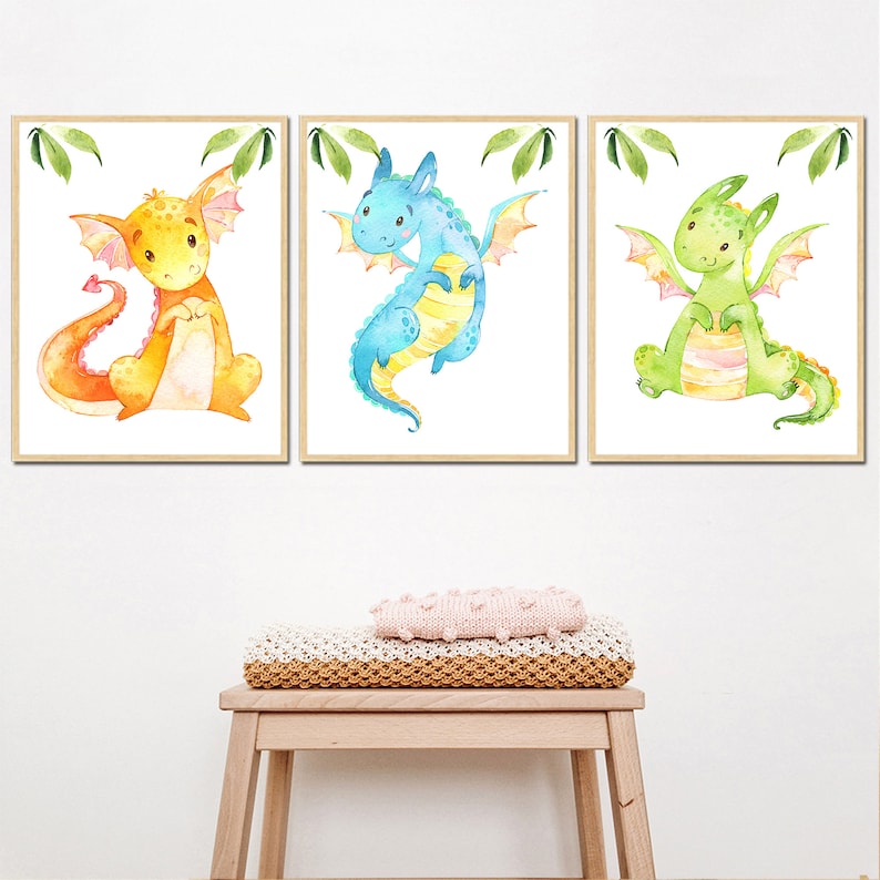 May include: Three watercolor paintings of cute dragons. The first dragon is orange with a yellow belly and wings. The second dragon is blue with a yellow belly and wings. The third dragon is green with a yellow belly and wings.